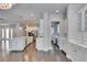 Open concept kitchen with stainless appliances, herringbone backsplash, lots of white cabinets and hardwood flooring at 5316 Candler View Dr, Lithia, FL 33547