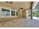 Covered lanai with travertine tile floors has a mounted fan and a view of the private backyard pool at 5316 Candler View Dr, Lithia, FL 33547