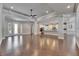 Large living room showcasing hardwood floors, tray ceilings, and natural light from large windows and glass front door at 5316 Candler View Dr, Lithia, FL 33547