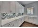 The pantry features custom shelves, quartz countertops, updated backsplash, and modern cabinets at 5316 Candler View Dr, Lithia, FL 33547