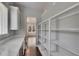 Pantry with custom shelves, quartz countertops, wine cooler, and view to kitchen at 5316 Candler View Dr, Lithia, FL 33547