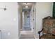 Hallway with light grey walls, an ornate chair, and decorative wall shelves leads to other areas of the home at 600 Eleuthera Dr, Punta Gorda, FL 33950