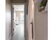 Hallway with light walls, modern flooring, and decorative shelves, leading to a sunlit room at 600 Eleuthera Dr, Punta Gorda, FL 33950