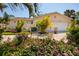 Single-Gathering home with a manicured lawn and garden beds with colorful flowers at 6001 19Th Ne St, St Petersburg, FL 33703