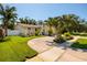 Well-kept single-story home with a circular driveway, tropical landscaping, and white fence at 6001 19Th Ne St, St Petersburg, FL 33703
