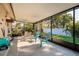 Enclosed patio featuring blue outdoor furniture, a fan, and views of the green backyard and white fence at 6001 19Th Ne St, St Petersburg, FL 33703