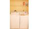 Laundry area with a white washer and dryer, featuring a shelf for storage of supplies at 6060 Shore S Blvd # 302, Gulfport, FL 33707