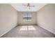 The bedroom features light colored walls and carpet, and a window for natural light at 6398 Bradford Woods Drive, Zephyrhills, FL 33542