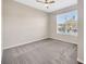 This is a view of a carpeted bedroom and large window at 6398 Bradford Woods Drive, Zephyrhills, FL 33542