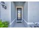 Inviting entryway featuring a modern front door, stylish sconce lighting, and a cheerful welcome mat at 6398 Bradford Woods Drive, Zephyrhills, FL 33542