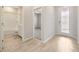 Bright hallway showcases wood-look tile flooring, leading to a bedroom, bathroom, and a glass-paneled door at 6398 Bradford Woods Drive, Zephyrhills, FL 33542