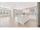 Open-concept kitchen with white cabinets, stainless steel appliances, a center island, and an adjacent living area at 6398 Bradford Woods Drive, Zephyrhills, FL 33542
