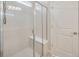 The glass enclosed shower features a built-in seat and tiled walls at 6398 Bradford Woods Drive, Zephyrhills, FL 33542