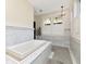 Bright bathroom featuring a soaking tub beneath shuttered windows, complemented by marble accents at 712 S Newport Ave, Tampa, FL 33606