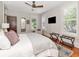 Bright bedroom with hardwood floors, shuttered windows, and a luggage rack near the bed at 712 S Newport Ave, Tampa, FL 33606