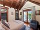 Inviting bedroom with hardwood floors, beamed ceilings, and access to an outdoor balcony at 712 S Newport Ave, Tampa, FL 33606