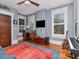 Bedroom with blue walls, a desk, multiple windows, and a guitar on display at 712 S Newport Ave, Tampa, FL 33606