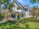 Inviting curb appeal with well-manicured lawn, lush landscaping, and a charming, light blue craftsman-style home at 712 S Newport Ave, Tampa, FL 33606