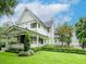 Beautiful two-story light blue craftsman-style house with a covered front porch and lush, green landscaping at 712 S Newport Ave, Tampa, FL 33606