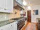 High-end kitchen with a professional-grade gas range, custom hood, and tile backsplash; a chef's dream come true at 712 S Newport Ave, Tampa, FL 33606