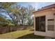 A spacious backyard with lush green grass and a tall brick wall bordering the property at 717 Lighthouse Dr, Tarpon Springs, FL 34689