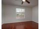 Clean bedroom with hardwood floors and a window overlooking the backyard at 717 Lighthouse Dr, Tarpon Springs, FL 34689