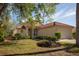 Charming single-story home featuring a red tile roof, well-maintained landscaping, and an attached two-car garage at 717 Lighthouse Dr, Tarpon Springs, FL 34689