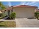 Home featuring a red tile roof, well-maintained landscaping, and an attached two-car garage at 717 Lighthouse Dr, Tarpon Springs, FL 34689