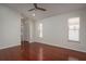 An airy main bedroom with two windows and a ceiling fan features wood floors and neutral paint at 717 Lighthouse Dr, Tarpon Springs, FL 34689