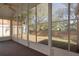 A screened in lanai has views of the fenced back yard and surrounding trees at 717 Lighthouse Dr, Tarpon Springs, FL 34689