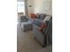 Comfortable living room with plush gray seating, accent pillows, and a cozy atmosphere at 7530 Broad Pointe Dr, Zephyrhills, FL 33540
