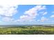 Picturesque aerial view of a lush landscape under a blue sky dotted with fluffy white clouds at 809 Butch Cassidy Trl, Wimauma, FL 33598