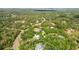Wide aerial view showcasing a neighborhood with homes nestled among trees, roads and natural landscape at 809 Butch Cassidy Trl, Wimauma, FL 33598