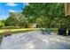 Lush backyard featuring a spacious patio, shed, manicured lawn, and mature trees for shade at 809 Butch Cassidy Trl, Wimauma, FL 33598