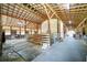 Spacious barn interior with high ceilings, wooden beams, and individual horse stalls. Well lit with mats on the floor at 809 Butch Cassidy Trl, Wimauma, FL 33598