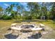 Community fire pit area with stone benches and an arbor for gatherings at 809 Butch Cassidy Trl, Wimauma, FL 33598