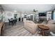 Open-concept living room featuring modern furniture, a cozy fireplace, and an adjoining kitchen with a breakfast bar at 8201 Ridge Rd, Seminole, FL 33772