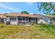 A nice backyard features a screened-in patio, lush green grass, and a well-manicured lawn at 8206 Leafy Ct, Port Richey, FL 34668
