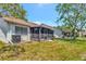An expansive backyard features a screened-in patio and well-maintained landscaping at 8206 Leafy Ct, Port Richey, FL 34668