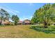 The expansive backyard is showcased with lush green grass and mature trees at 8206 Leafy Ct, Port Richey, FL 34668