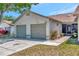 Well-kept home featuring an attached two-car garage, cozy screened porch, and landscaped yard at 8206 Leafy Ct, Port Richey, FL 34668