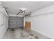 View of garage interior showing concrete floor, garage door, and shelving at 8206 Leafy Ct, Port Richey, FL 34668