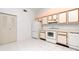 Bright kitchen featuring white appliances, tile floor, and ample cabinet space at 8206 Leafy Ct, Port Richey, FL 34668