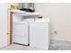 Bright laundry room features a washer and dryer and practical shelving at 8206 Leafy Ct, Port Richey, FL 34668