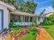 Cozy screened-in porch with brick flooring, seating area, and beautiful plants for relaxing outdoors at 8326 40Th N Pl, St Petersburg, FL 33709