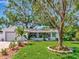 Charming single-story home with a well-manicured lawn, beautiful trees, and a cozy screened-in porch at 8326 40Th N Pl, St Petersburg, FL 33709