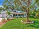 Charming single-story home with a well-manicured lawn, beautiful trees, and a cozy screened-in porch at 8326 40Th N Pl, St Petersburg, FL 33709