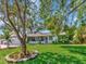 Inviting single-story home with lush green lawn, mature tree, and a quaint screened-in porch at 8326 40Th N Pl, St Petersburg, FL 33709
