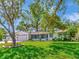 Charming single-story home with a lush green lawn, mature tree, and a quaint screened-in porch at 8326 40Th N Pl, St Petersburg, FL 33709