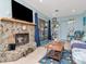 Inviting living room with a stone fireplace, large TV, and access to the pool area through sliding glass doors at 8326 40Th N Pl, St Petersburg, FL 33709